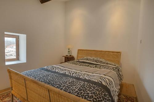 Un dormitorio con una cama con una manta. en la maison magique en Mailhac