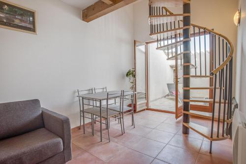 un salon avec un escalier et une table dans l'établissement la maison magique, à Mailhac