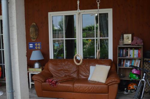 un sofá de cuero marrón en una habitación con ventana en Box58 en Eisenstadt
