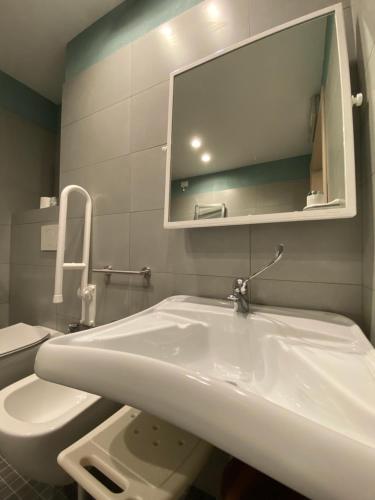 a bathroom with a white sink and a toilet at Delta Park in Porto Viro