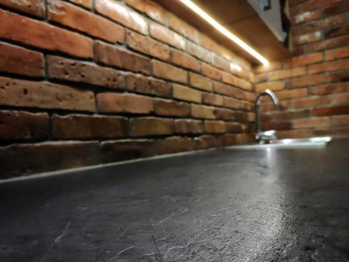 an empty room with a brick wall and a concrete floor at Willa Kania in Szczawnica