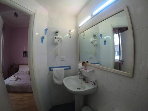 ein Bad mit einem Waschbecken und einem Spiegel in der Unterkunft Valerie in La Spezia