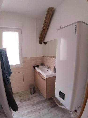 une salle de bain blanche avec un lavabo et une fenêtre dans l'établissement Les Nuits Bonneuilloises Le Mustang, à Bonneuil-les-Eaux