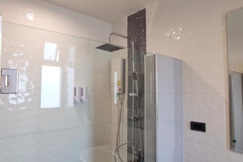 a bathroom with a shower with a glass door at De Vine House in Roi Et