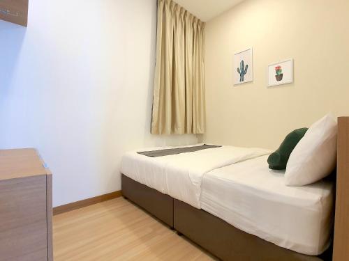 a bedroom with a bed and a dresser and a window at The Wave Suites Melaka in Melaka