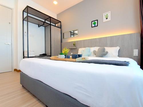 a large white bed in a bedroom with a mirror at The Wave Suites Melaka in Melaka