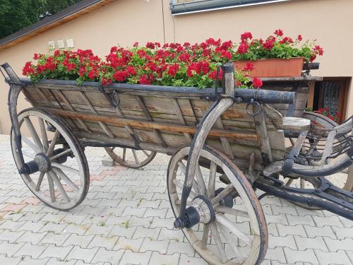 a wooden cart with red flowers in it at Apartman centrum v súkromí Reštaurácia U Jakuba in Martin