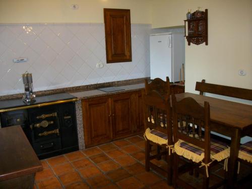 a kitchen with a wooden table and a stove top oven at Casa de Aldea Rural Los Glayus in Luarca