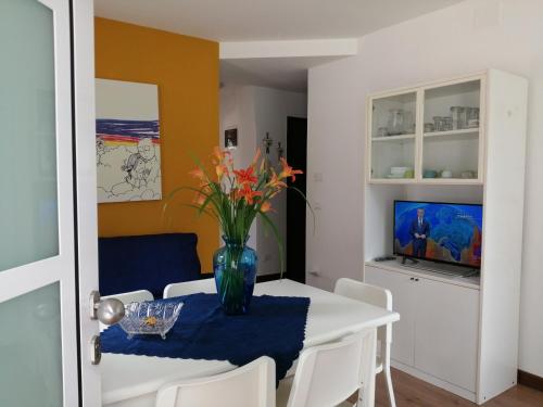 une salle à manger avec une table et un vase de fleurs. dans l'établissement Appartamento al sole, à Pieve di Cadore