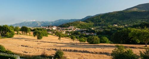 a village in a field with mountains in the background at Hotel Hermitage in Polla