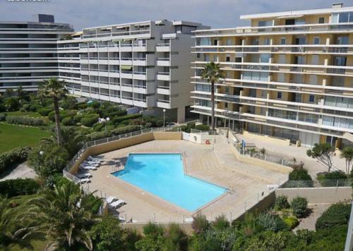 une piscine vide en face d'un grand bâtiment dans l'établissement Superbe appartement face à la mer avec parking privatif, à Canet
