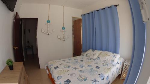 a bedroom with a bed and a blue curtain at Marmows Place in San Andrés