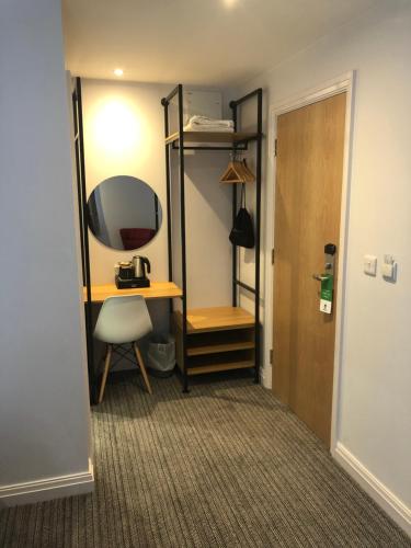 a room with a desk and a mirror and a door at Best Western Lancaster Morecambe Lothersdale Hotel in Morecambe