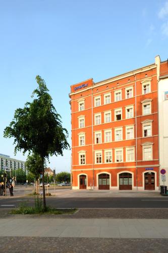 a large orange building on the side of a street at SchlafGut AppartementHotel in Leipzig