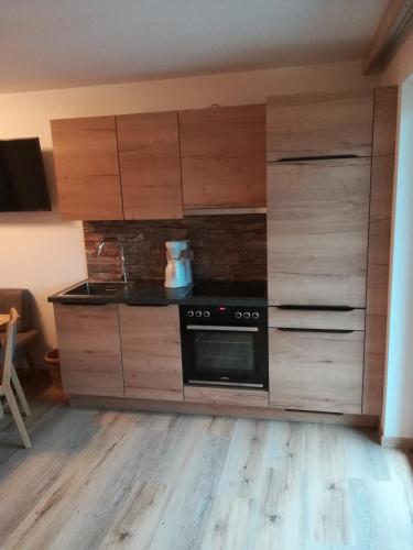 a kitchen with wooden cabinets and a stove at Haus Garz in Weissensee