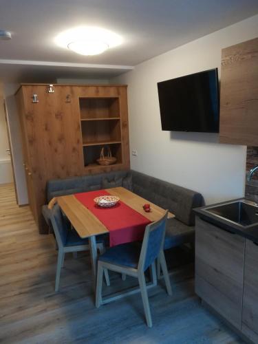 a kitchen and dining room with a table and a couch at Haus Garz in Weissensee