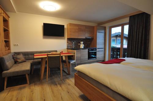 a bedroom with a bed and a table and a kitchen at Haus Garz in Weissensee