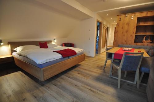 a bedroom with a bed and a desk and a table at Haus Garz in Weissensee
