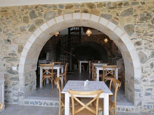 a restaurant with tables and chairs in a stone wall at La Casa della Filanda in Belmonte Calabro