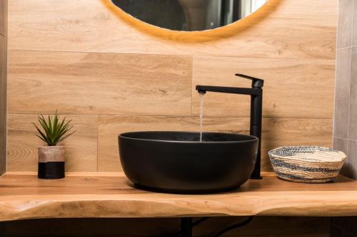 a black bathroom sink with a faucet at Costa D' Ifesto in Agios Ioannis Kaspaka