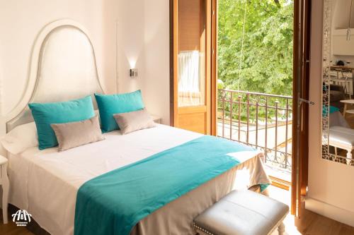 ein Schlafzimmer mit einem großen Bett und einem Balkon in der Unterkunft AiA LOFT BIBRAMBLA in Granada