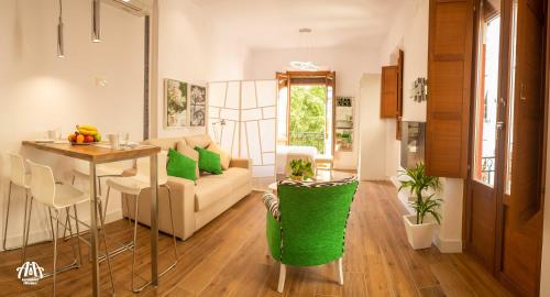 ein Wohnzimmer mit einem Sofa und einem Tisch in der Unterkunft AiA LOFT BIBRAMBLA in Granada