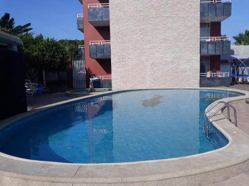 una gran piscina frente a un edificio en Hotel Almond Beach en Tonsupa