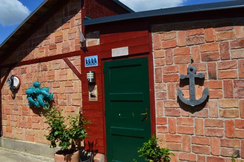 a red brick building with a green door at Bootshaus in Eisenstadt