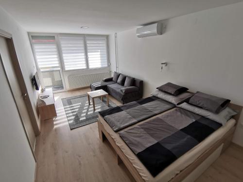 a bedroom with a large bed and a couch at Sweet Life Apartman in Eger