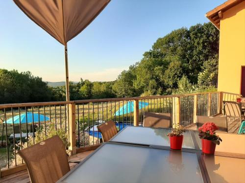 a patio with a table and chairs on a deck at Le Grand Noyer in Ambronay