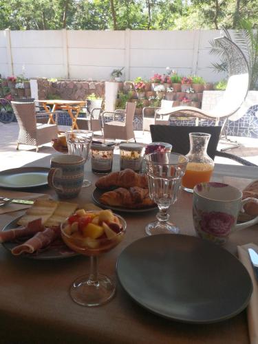 une table avec des assiettes de nourriture et des verres dessus dans l'établissement LES CHAMBRES DU HOURON, à Moliets-et-Maa