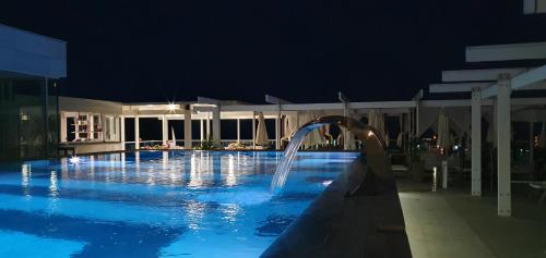 a swimming pool at night with a water fountain at Apartments Menuet in Budva