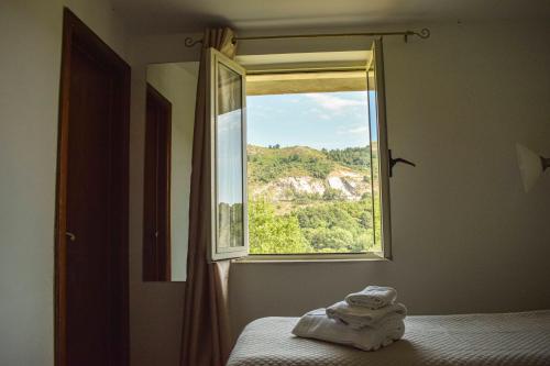 Affittacamere D'amore في Foria: غرفة نوم مع نافذة عليها مناشف