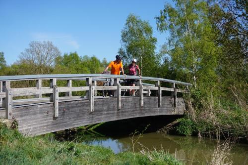 two people standing on a bridge over a river at Reichels Parkhotel in Bad Windsheim