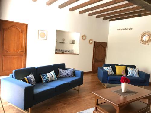 a living room with two blue couches and a table at La Diguinerie in Prignac