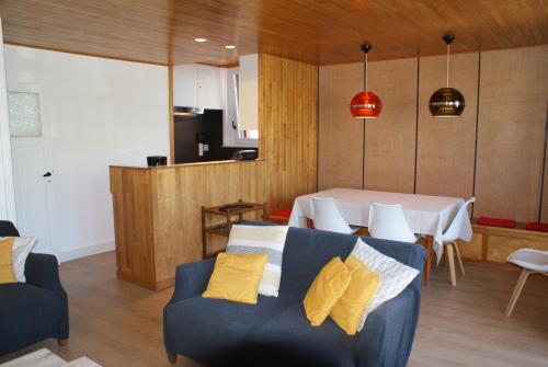 a living room with a blue couch and a table at Belle Villa in De Panne