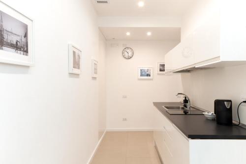 a kitchen with a counter and a clock on the wall at Maison Altinia in Treviso