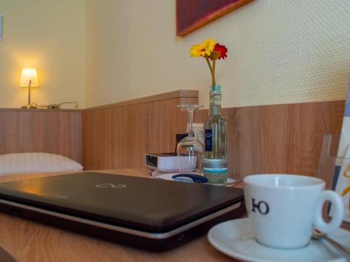 een laptop computer op een tafel met een kopje koffie bij Trierer Hof in Koblenz