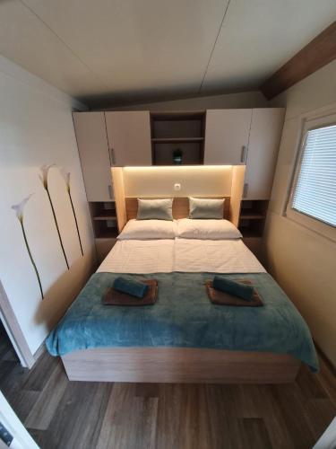 a bedroom with a large bed with two pillows at Mobile Home M&M in Drage