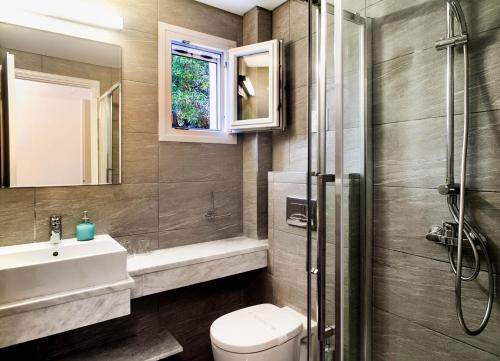 La salle de bains est pourvue de toilettes, d'un lavabo et d'une douche. dans l'établissement Nefeli Hotel, à Agios Nikitas