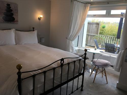 メバギシーにあるLinton Luxury Holiday Homeのベッドルーム1室(ベッド1台、デスク、窓付)