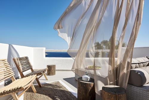 a bedroom with a view of the ocean from a balcony at Palladium Hotel in Platis Yialos Mykonos