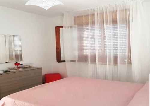 una camera con letto rosa e finestra di Vista Volo a Pontecagnano