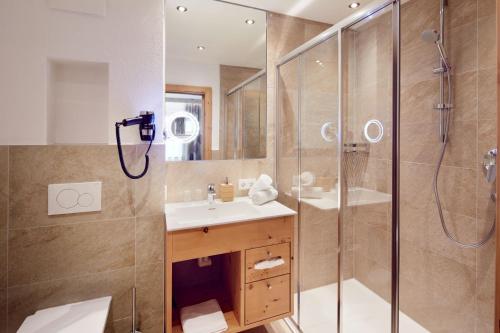 y baño con ducha y lavamanos. en Hotel Gasthof Abelhof, en Neukirchen am Großvenediger