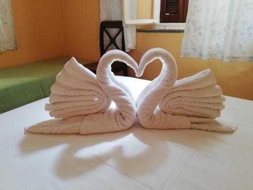 two towels shaped like swans sitting on a bed at Hotel Anastasia in Rhodes Town