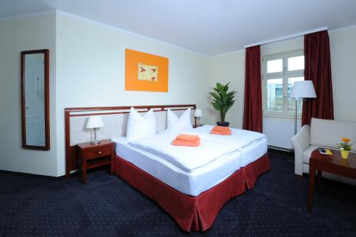 a hotel room with a large bed and a chair at SchlafGut AppartementHotel in Leipzig