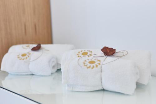 three towels with flowers on them sitting on a table at Euphoria House in Poros