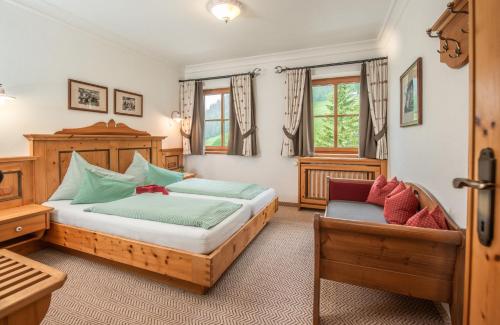 a bedroom with two beds and a chair in it at Brandhof in Ramsau am Dachstein