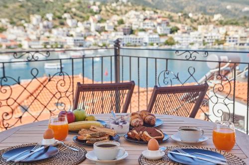 - une table avec des aliments et des jus de fruits pour le petit-déjeuner sur un balcon dans l'établissement Euphoria House, à Poros