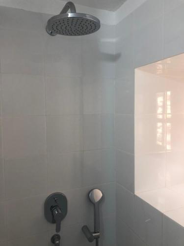 La salle de bains est pourvue d'une douche avec une lumière sur le mur. dans l'établissement Casas Rurales Hermigua, à Hermigua